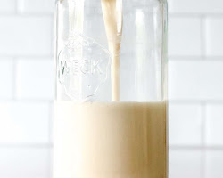 Milk being poured into a glass jar